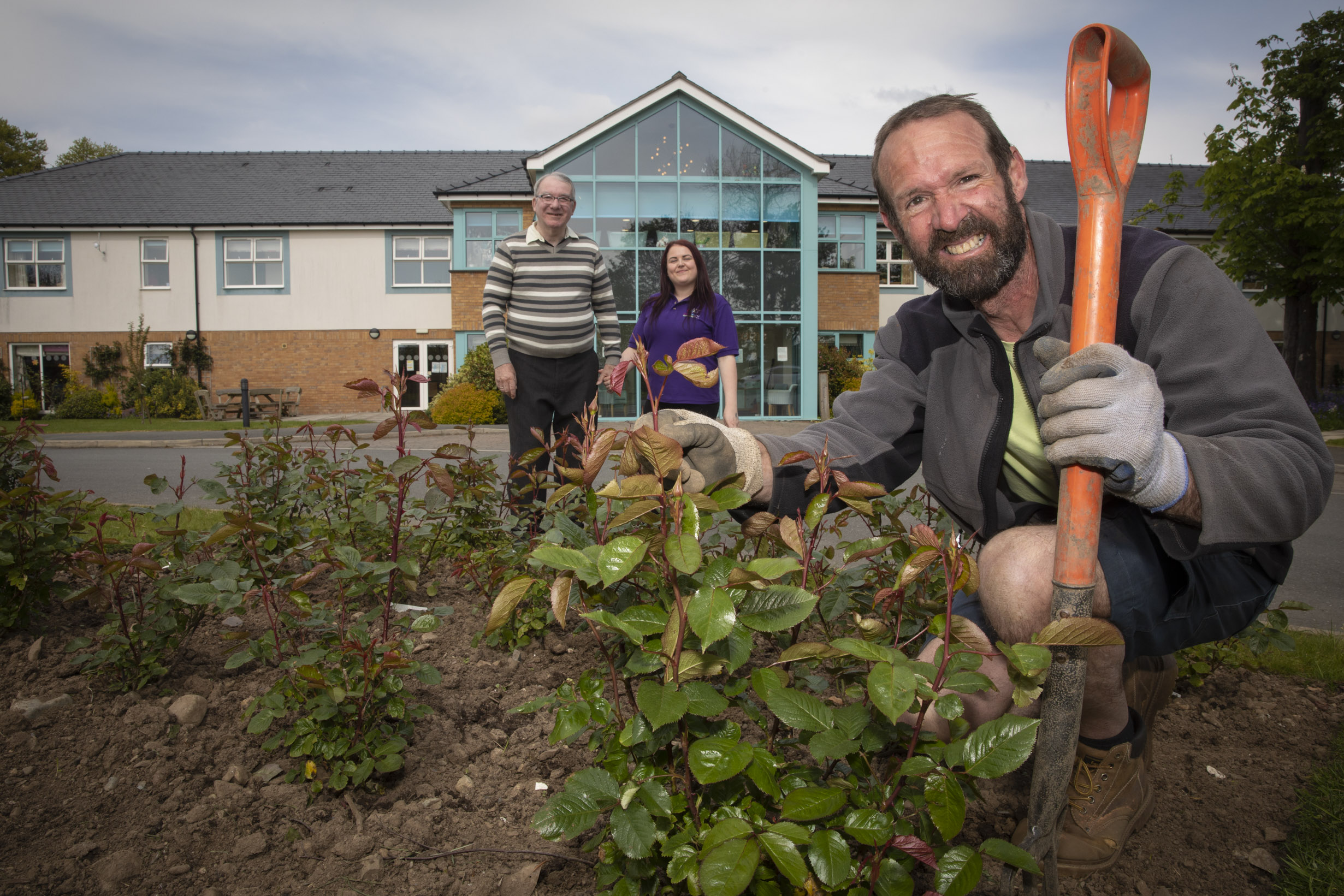 A bed of roses has been planted at Pendine Park's Bryn Seiont Newydd care home in Caernarfon to  celebrate the Queen's Platinum Jubilee. Local landscape gardener Gwilym Roberts, resident David Edwards and enrichment co-ordinator Audrey Phillips.